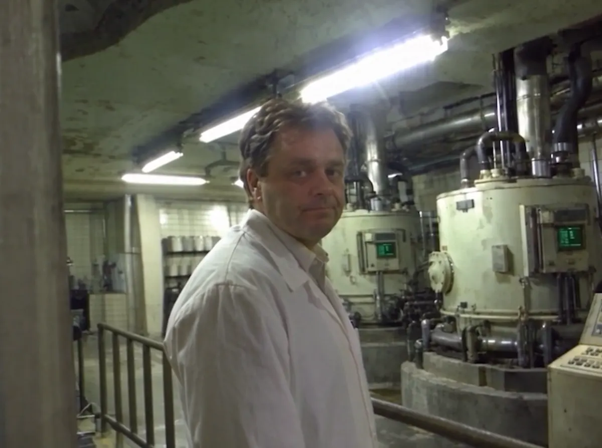 Portrait of Peter in a lab coat in front of the processor tanks